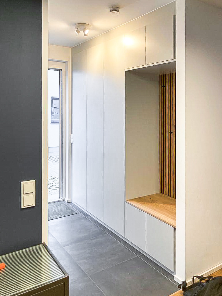 Garderobe in weiß mit Sitznische und Holzpaneelen